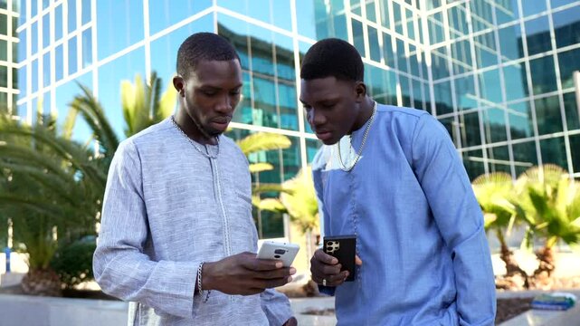 Senegalese businessmen discussing over mobile phone in dashiki