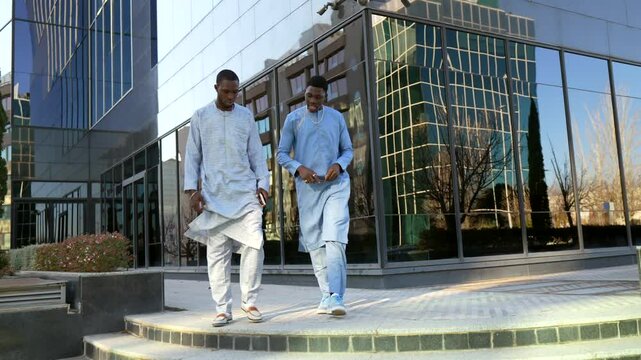 Senegalese businessmen walking and talking in dashiki