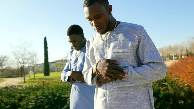 Senegalese muslims performing salat prayer in public park