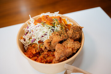 Korean fried chicken and salad in a rice bowl.