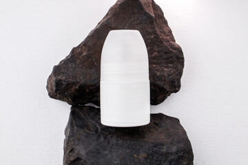 Unique white container resting on black rocks in a minimalist setting with soft lighting