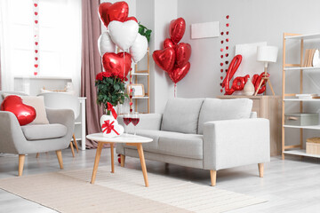 Interior of light living room decorated for Valentine's Day with balloons, sofa and armchair