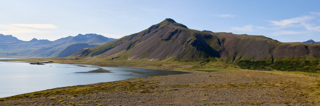 Mountain fjord landscape in Iceland with coastal terrain. Dramatic cliffs meet calm waters under summer sky - Powered by Adobe