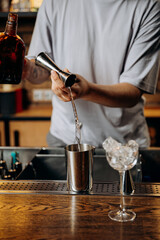 Bartender pouring liquor into a jigger, showcasing the precision of cocktail craftsmanship