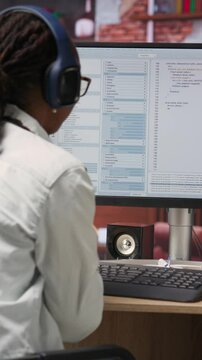 Vertical video Cheerful software developer at computer waiting for code to finish compiling, celebrating after managing to make it run without errors. Woman happy after finishing work on algorithm