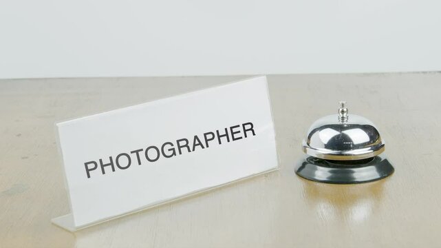 Photographer Office or Room with Hand Ringing The Bell on Desk or Table Multiple Times