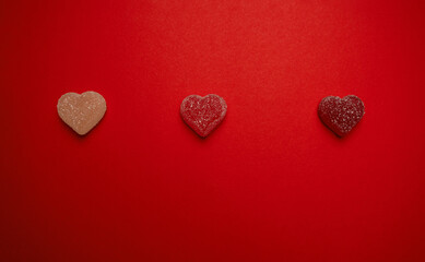 Heart-shaped gummy candies on a vibrant red background, symbolizing love and romance. Perfect for Valentine's Day themes, holiday promotions, greeting cards, and romantic celebrations