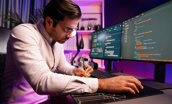 Working smart IT developer writing data software development from two pc screen, creating application program updated version online website page system online at neon light cyber office. Surmise.