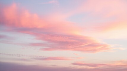 A stunning sunset sky displaying soft pink and purple hues with wispy clouds blending seamlessly into pale blue, evoking calm and serenity.