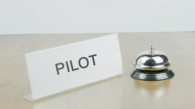 Pilot Office or Room with Hand Ringing The Bell on Desk or Table Multiple Times