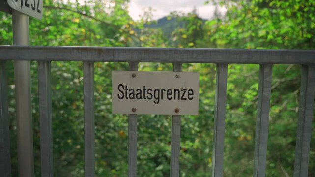 Schilder Grenze zwischen Deutschland und Oesterreich. Tafel Staatsgrenze. Politische Grenze. Schild Grenzlinie zwischen Staatsgebieten. Fence sign State border in Germany. Border inscription in German