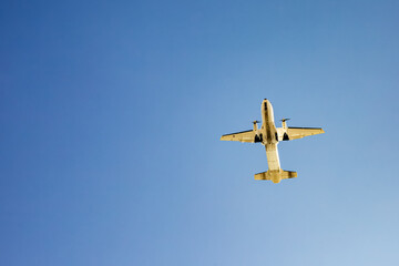 Passenger airplane soaring in clear blue sky underneath view