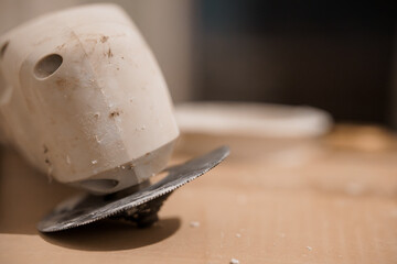 Close-Up of a Dirty Circular Saw Blade with a White Handle on a Wooden Surface