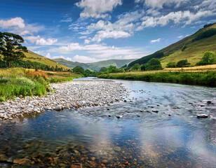 Fototapeta premium A tranquil river at the mountain’s edge meandering across lush, flat terrain.