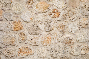 Rustic stone wall texture with beige and orange hues