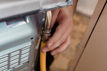 Professional Technician Connecting Gas Line to Oven for Installation