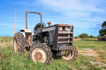 Black agricultural tractor outside on the farm in a rural area.