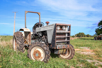 Grey agricultural tractor outside on the farm in a rural area.