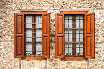 Rustic stone wall with wooden shuttered windows