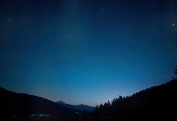 Fototapeta premium Night sky with shooting stars over dark mountains, forest. Celestial display with bright stars, meteors. Silhouettes of trees, hills. Dark blue sky. Long exposure photo captures cosmic beauty. Nature
