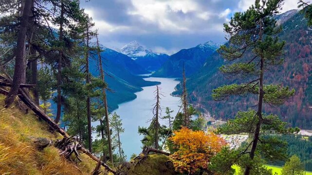  Plansee lake among snow-capped mountains in Tyrolean Alps, Austria late autumn in cloudy weather. . High quality 4k footage
