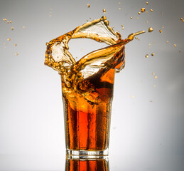 glass of ice cold cola with splashes