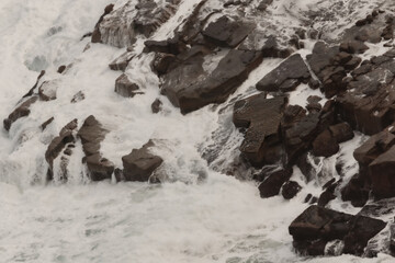 Interesting rock in shape of Australia in rough water