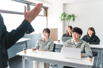 会議・ミーティング・プレゼンを聞く作業着姿のビジネスマン男女
