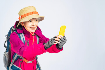 登山客、シニア、女性、スマートフォン、日本人、スマホ、撮影、写真、アウトドア、レジャー、登山、観光、旅行、笑顔、動画、記念、装備、アクティブ、観光客、用品、高齢者、お年寄り、おばあちゃん、おばあさん、60代、ハイキング、トレッキング、元気、SNS、メール、帽子、リュック、ウィンドブレーカー、ジャケット、カラフル、ファッション、健康、ヘルスケア、楽しい、ハイカー、スポーツ、趣味、コピースペース、見つ