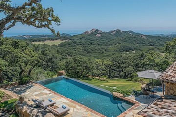 Fototapeta premium A stunning outdoor scene featuring a luxurious pool overlooking a picturesque landscape of rolling hills and lush greenery under a clear blue sky.
