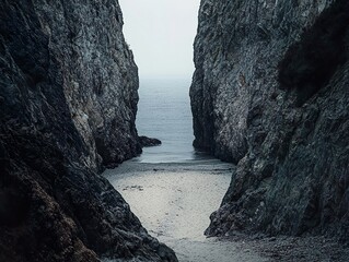 A narrow passage between rocky cliffs with a view of the ocean in the distance creates a dramatic...