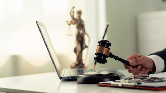 Lawyers working with documents Law, advice and justice concept, lawyer in suit signing legal document at table with justice scale, close-up
