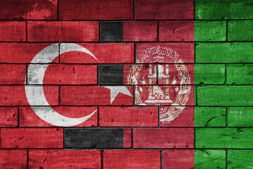 colourful painted big flag of turkey and flag of afghanistan on a massive old brick wall...