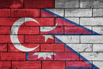 colourful painted big flag of turkey and flag of nepal on a massive old brick wall background....