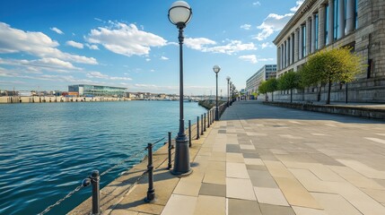Sunny waterfront promenade with modern architecture and lampposts.