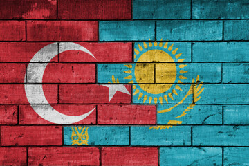 colourful painted big flag of turkey and flag of kazakhstan on a massive old brick wall background. concept