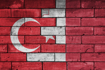 colourful painted big flag of turkey and flag of malta on a massive old brick wall background....