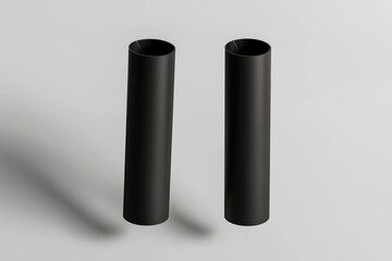 Matte black floating paper tubes with soft shadows, isolated on light grey for a minimal look.
