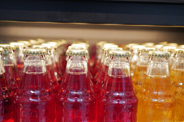Colorful glass bottles filled with soft drinks displayed prominently
