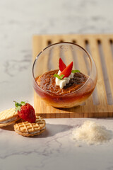 A dessert with strawberries and whipped cream in a glass bowl