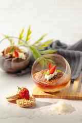 A dessert with strawberries and whipped cream in a glass bowl