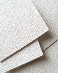 Fototapeta premium A close-up view of textured, off-white paper sheets stacked together, showcasing their unique surface patterns.