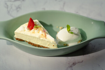 A slice of cheesecake with a strawberry on top
