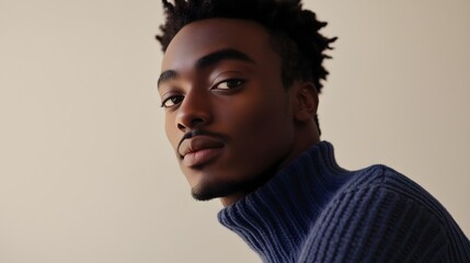Fototapeta premium Portrait of a young man with dark skin and textured hair, wearing a turtleneck sweater.