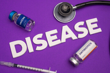 Vaccine antibiotics and a stethoscope lie near the word DISEASE. Disease awareness background concept