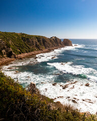 Fototapeta premium Coastal cliffs overlooking beach and ocean on a clear blue day