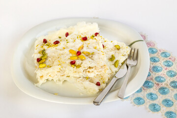 Traditional,Turkish Ramadan Dessert Gullac one portion on plate with cutlery and blue lace
