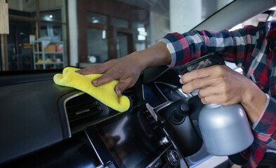 Man's hands cleaning the inside of the car