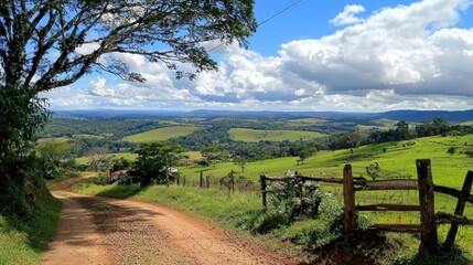 Rural road descends, scenic valley view, cloudy sky, pasture, travel