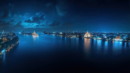 Fototapeta premium Night Panorama of Bangkok's Chao Phraya River with Illuminated Temples and City Skyline